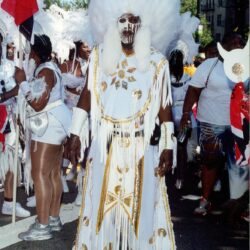 Parade participant in white feathered ceremonial costume