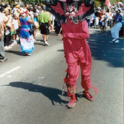 Masked performer in red carnival costume