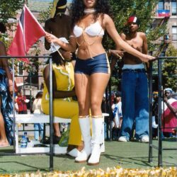 Woman dancing on parade float holding flag