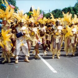Parade performers in gold feathered carnival costumes