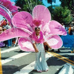 Parade performer wearing large pink flower costume