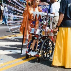 Colorful parade performer in wheelchair with wings
