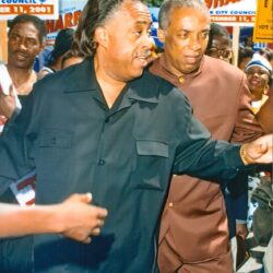 Two men at crowded outdoor campaign rally