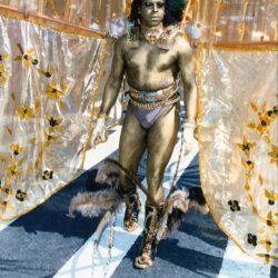 Carnival performer in gold body paint and wings