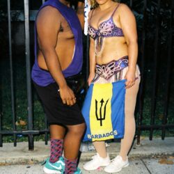 Two carnival participants posing with Barbados flag