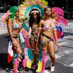 Three women in colorful carnival costumes