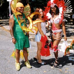 Three people in colorful carnival costumes