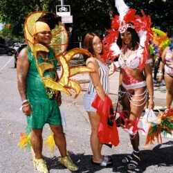 Three people in colorful carnival outfits