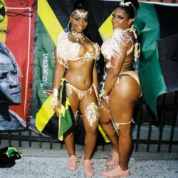 Two women in carnival costumes with Jamaican flag