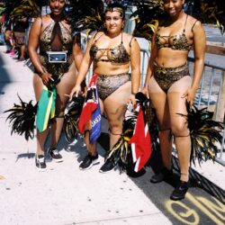 Three women in gold feathered carnival costumes