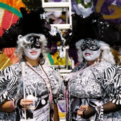 Two masked people in elaborate carnival costumes