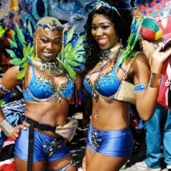 Two smiling women in blue feathered carnival costumes