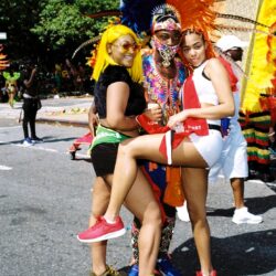 Two women with costumed performer at parade