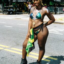Carnival performer in green bikini with Jamaican flag