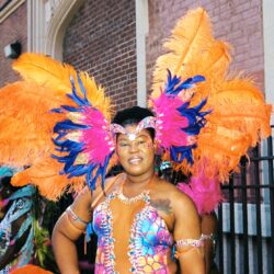 Carnival performer wearing colorful feathered headdress