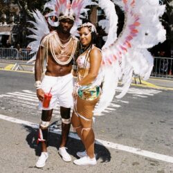 Two carnival performers in white feathered costumes