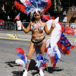Carnival dancer in red, white, blue feathers
