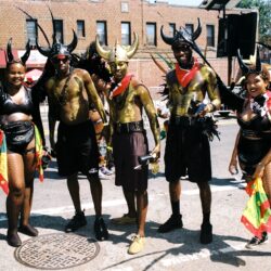 Carnival group in gold body paint and horns