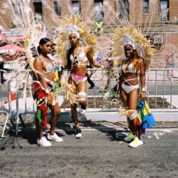 Three women in feathered carnival parade costumes