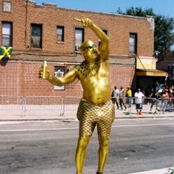 Gold-painted street performer in fishnet leggings