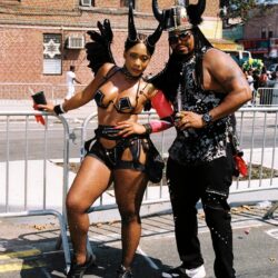 Two people in black horned carnival costumes