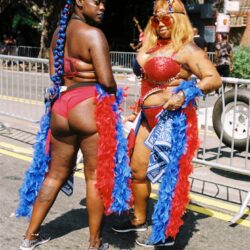 Two women in red carnival costumes and boas