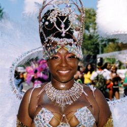 Smiling performer in ornate jeweled carnival costume