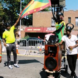 Street performers with Grenada flag and speaker