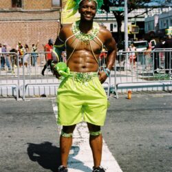 Person in neon green carnival costume with headdress