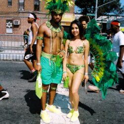 Carnival performers in green feathered costumes