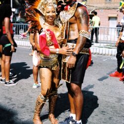 Couple wearing vibrant feathered carnival costumes