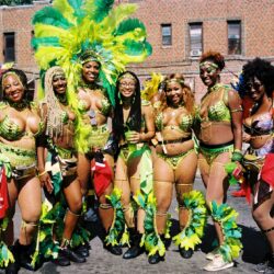 Parade performers in green feathered carnival costumes