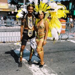 Two carnival performers in yellow feathered costumes