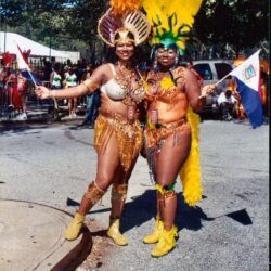 Two women in colorful feathered carnival costumes