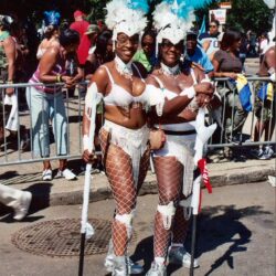 Two women in carnival costumes with blue feathers.
