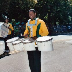 Marching band drummer in yellow-green uniform