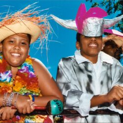 Smiling children in colorful leis and hats