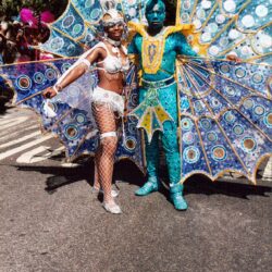 Two carnival performers in blue peacock costumes