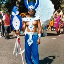 Person in blue carnival costume holding staff