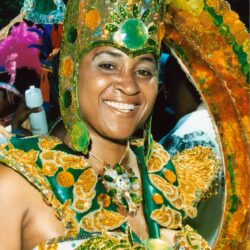 Smiling woman in green and gold carnival costume
