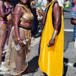 Two people in colorful carnival costumes on street