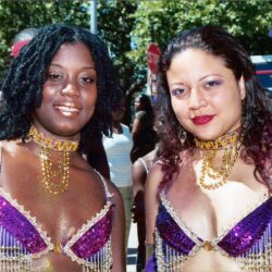 Two women wearing purple sequined carnival costumes