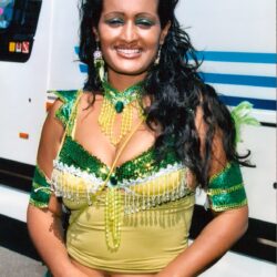 Smiling woman in green sequined carnival costume