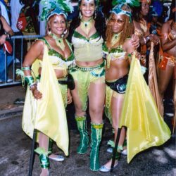 Three women in green and yellow carnival costumes