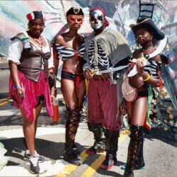 Four people in colorful pirate carnival costumes