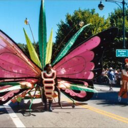 Parade performer wearing large pink butterfly costume