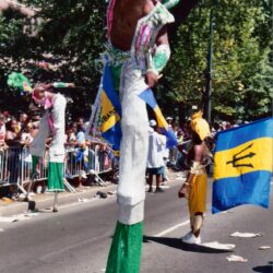 Stilt performer with Barbados flag at parade
