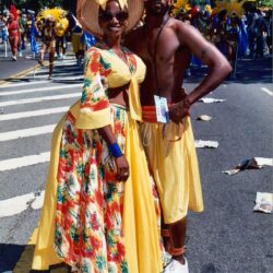 Smiling couple in vibrant yellow carnival costumes