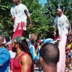 Stilt walkers wearing shredded shirts at parade