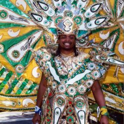 Carnival performer in feathered green and gold costume